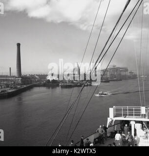 1950, storico, vista sul canale del porto di Belfast che mostra i cantieri navali, gru e banchina che erano tutti attivi in questo periodo, Belfast, Irlanda del Nord, Regno Unito. Foto Stock