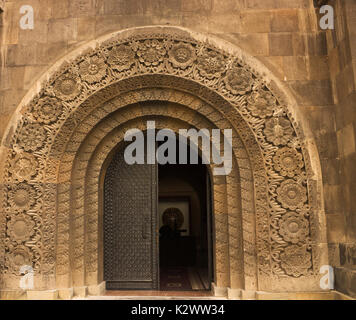 Un museo arcuato portale con sculture e le porte di metallo in Armenia. Foto Stock