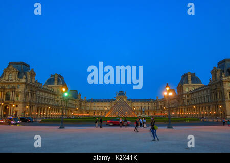 Il museo del Louvre piramide in vetro e un cortile di notte a Parigi, Francia. Foto Stock