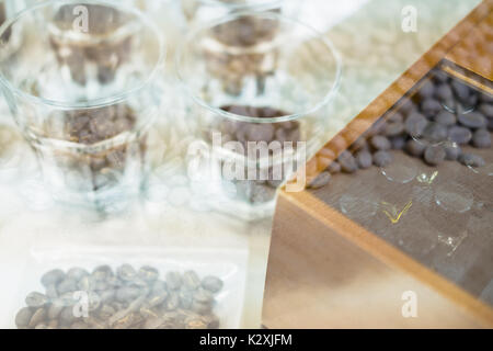 Bicchiere di caffè per un degustatore di odore e sapore aromatico e di sapore ruota. arte della percezione di aroma di caffè appena preparato doppia esposizione con chicco abbrustolito. c Foto Stock