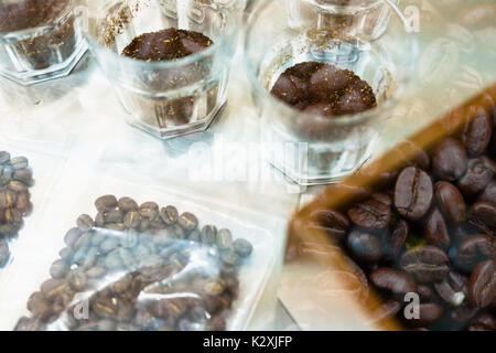 Bicchiere di caffè per un degustatore di odore e sapore aromatico e di sapore ruota. arte della percezione di aroma di caffè appena preparato doppia esposizione con chicco abbrustolito. c Foto Stock