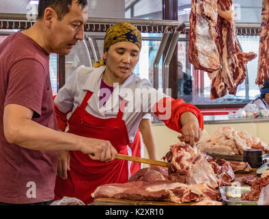 Distributore vende carne ad un mercato locale a Bishkek, Kirghizistan il 27 maggio 2017 Foto Stock