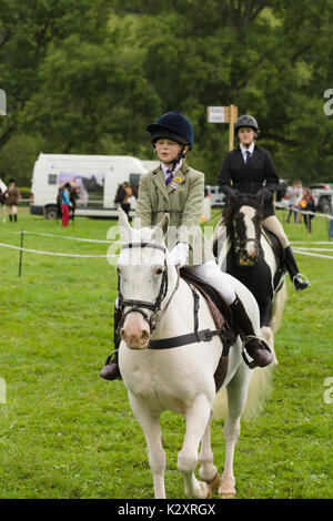 Giovani piloti e i loro cavalli in competizione nella gymkhana all annuale Ceiriog Valley Sheep Dog prove in Glyn Ceiriog Galles del Nord Foto Stock