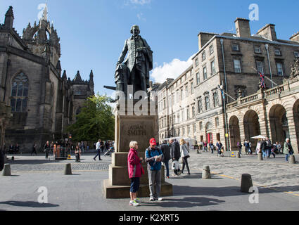 Turisti sotto la Adam Smith statua in Edinburgh Royal Mile. Foto Stock