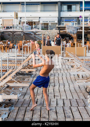 Un giovane ragazzo prende una buffa selfie su un molo in Juan les Pins, Francia Foto Stock