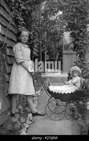 AJAXNETPHOTO. 1910 (circa). Londra, Inghilterra. - Ragazza giovane con bambola vittoriana della PRAM con bambola. fotografo:sconosciuto © IMMAGINE DIGITALE COPYRIGHT VINTAGE AJAX Picture Library Fonte: AJAX FOTO VINTAGE COLLEZIONE REF:PRAM 1910 Foto Stock