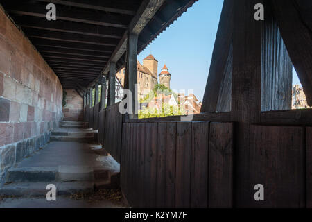 Il castello di Norimberga nel sole pomeridiano da guardie passerella sulla parete con un tetto in legno Foto Stock