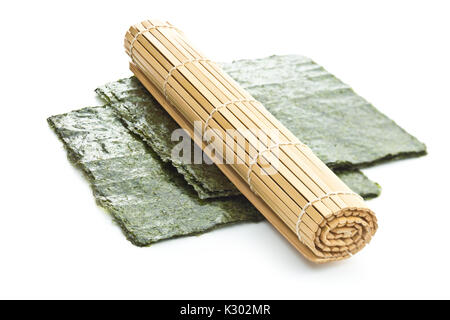 Verde foglio di Nori e tappetino di bambù isolati su sfondo bianco. Foto Stock