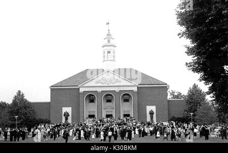 Johns Hopkins University laureati e i loro cari sono riuniti nella parte anteriore di un edificio scolastico a seguito dell università di classe 1963 cerimonia di inizio a Baltimora, Maryland, 11 giugno 1963. Foto Stock