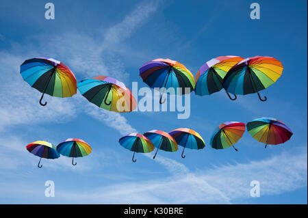 Rainbow ombrelloni colorati galleggianti nel cielo Foto Stock