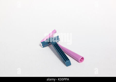 Un blu monouso Schick & rosa Bic rasoio usa e getta entrambi realizzati in materiale plastico polipropilene. Foto Stock