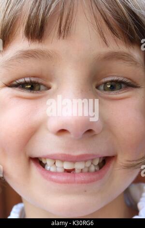 Close up ritratto di una giovane ragazza che ha appena perso il suo primo dente Foto Stock