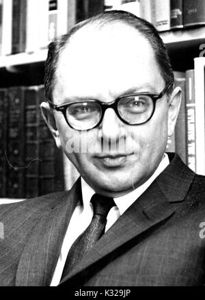 Ritratto fotografia di storico americano e biografo David Herbert Donald seduti di fronte a scaffali, 1962. Foto Stock