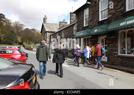 I turisti a piedi lungo College Street nel centro del villaggio di Grasmere nel Distretto del Lago, Cumbria Foto Stock