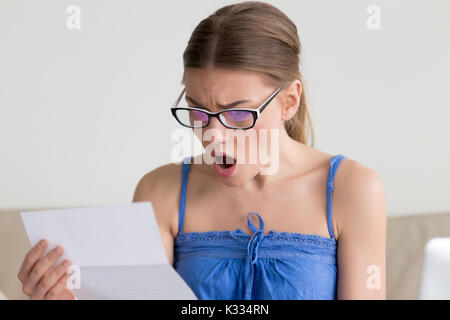 Donna scioccati quando lettura la lettera con le cattive notizie Foto Stock