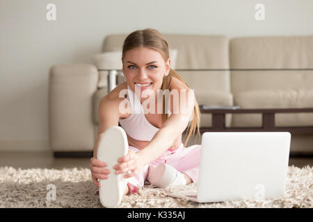 Donna facendo stretching esercizi di fitness in casa Foto Stock