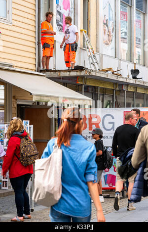 Kristiansand, Norvegia - 16 agosto 2017: Travel documentario di lavoratori edili lavorando sul rinnovamento del ripiano del tetto al di sopra della strada. Foto Stock