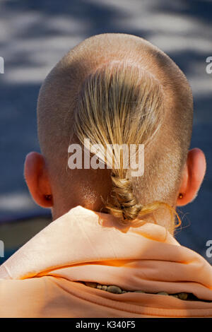 Una vista dalla parte posteriore di un maschio Hare Krishna devoto che mostra la sua singolare taglio di capelli. In Union Square Park a Manhattan, New York City Foto Stock