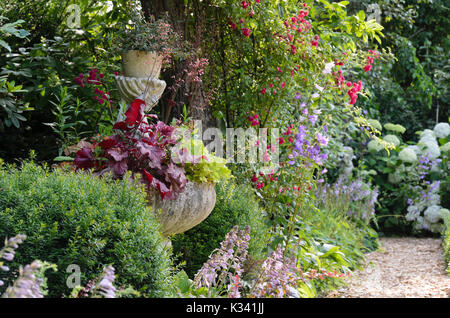 Fontana con alumroots (heuchera) e piantaggine gigli (hosta). design: marianne e detlef lüdke Foto Stock