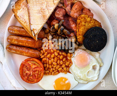 Tradizionale prima colazione inglese. Uova fritte, fagioli al forno, bacon, salsicce e pane tostato Foto Stock