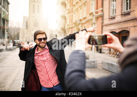 La foto di un giovane uomo che pongono alla foto e divertirsi. Foto Stock
