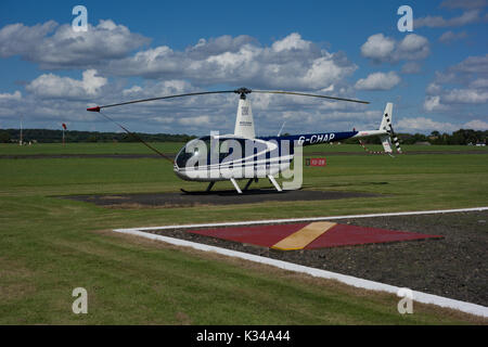 Elicottero parcheggiato su erba. Wolverhampton Halfpenny Green Airport. South Staffordshire. Regno Unito Foto Stock