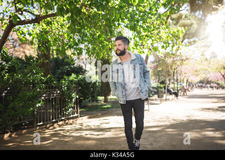 Una foto di giovani, uomo bello facendo una passeggiata al parco. Foto Stock