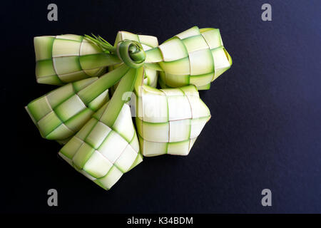 Gnocco di riso involucro o anche sapere come ketupat realizzato da noce di cocco di foglie di palma su sfondo nero. Ketupat è un tipo di gnocco fatto dal riso pranzo insi Foto Stock