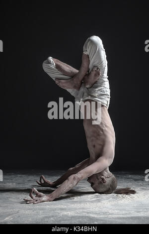 Yoga flessibile man standing in yoga headstand shirshasana pongono. Foto Stock