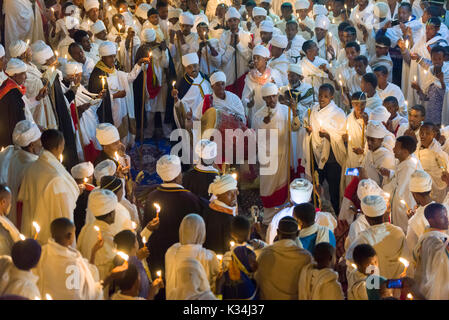 I sacerdoti canti preghiere a lume di candela nel cortile di Bet Medhane Alem chiesa, durante la preghiera sulla chiesa ortodossa etiope Sabato di Pasqua, Lalibela, Etiopia Foto Stock