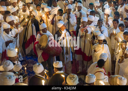 I sacerdoti canti preghiere a lume di candela nel cortile di Bet Medhane Alem chiesa, durante la preghiera sulla chiesa ortodossa etiope Sabato di Pasqua, Lalibela, Etiopia Foto Stock