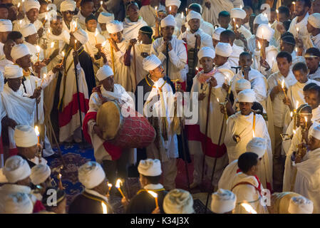 I sacerdoti canti preghiere a lume di candela nel cortile di Bet Medhane Alem chiesa, durante la preghiera sulla chiesa ortodossa etiope Sabato di Pasqua, Lalibela, Etiopia Foto Stock