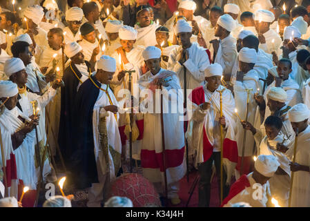 I sacerdoti canti preghiere a lume di candela nel cortile di Bet Medhane Alem chiesa, durante la preghiera sulla chiesa ortodossa etiope Sabato di Pasqua, Lalibela, Etiopia Foto Stock