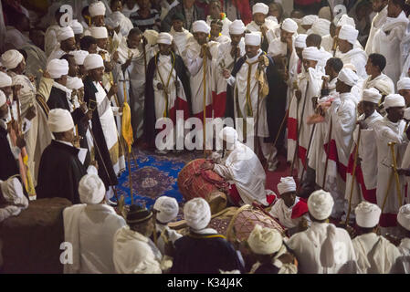 I sacerdoti canti preghiere a lume di candela nel cortile di Bet Medhane Alem chiesa, durante la preghiera sulla chiesa ortodossa etiope Sabato di Pasqua, Lalibela, Etiopia Foto Stock