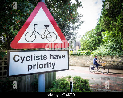 I ciclisti hanno priorità Cassetta di sicurezza - Escursioni in bicicletta - Segno dirigere le vetture per dare modo ai ciclisti su un intenso percorso ciclabile nel centro di Cambridge Regno Unito Foto Stock