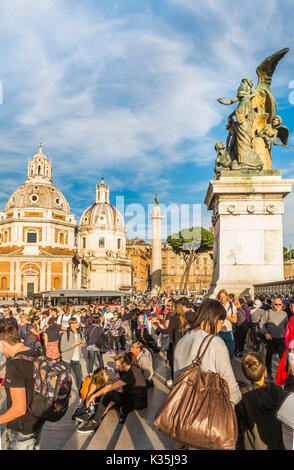 I turisti a piazza Venezia nella parte anteriore della scultura in bronzo all'entrata al monumento nazionale a Vittorio Emanuele II, Santa Maria di Loreto e San Foto Stock