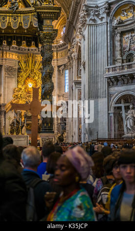 I visitatori all'interno della basilica di san Pietro, altare con berninis baldacchino e cathedra petri e gloria in background Foto Stock