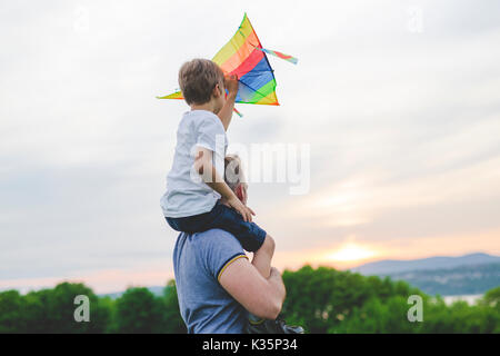 Padre e figlio sul prato con un aquilone in estate Foto Stock