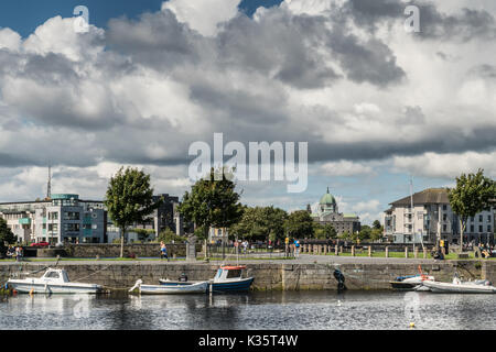 Galway, Irlanda - 5 agosto 2017: grigio scuro e bianco cloudscape bassa sul profilo della città con la cupola della cattedrale e altri edifici. visto dal po Foto Stock