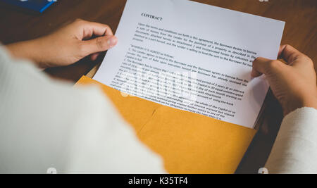 Le donne stanno aprendo una busta documento circa la firma di un contratto per il business e firmare il contratto concetto,stile vintage Foto Stock