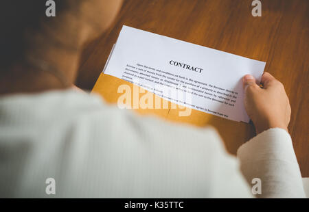 Le donne stanno aprendo una busta documento circa la firma di un contratto per il business e firmare il contratto concetto,stile vintage Foto Stock