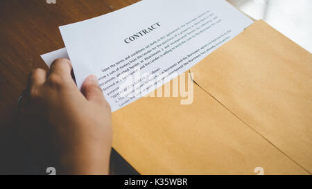 Le donne stanno aprendo una busta documento circa la firma di un contratto per il business e firmare il contratto concetto,stile vintage Foto Stock