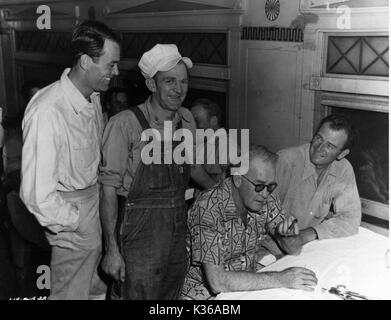 SANTA FE ENGINEER TOM GRAY attende di ricevere il segnale dal regista JOHN FORD PER AVVIARE IL TRENO prendere l'equipaggio in Arizona per iniziare le riprese FORT APACHE mentre Henry Fonda e John Wayne a guardare. FORT Apache è stato rilasciato nel 1948. Foto Stock