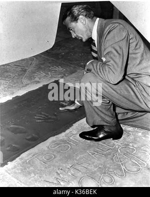 Gary Cooper rendendo handprints in cemento umida al di fuori del Sid Grauman's Chinese Theatre di Hollywood Foto Stock