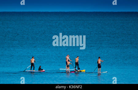 Aberystwyth Wales UK, sabato 02 settembre 2017 UK Meteo - su un luminoso e caldo settembre mattina un gruppo di amici andare paddleboarding sulla calma piatta mare off Aberystwyth Wales. Il clima è impostato su Modifica per tutta la notte, girando coperto con una fascia di spazzamento di pioggia da ovest Photo credit: Keith Morris/Alamy Live News Foto Stock