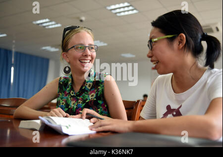 Xiamen, cinese della provincia del Fujian. 26 Ago, 2017. Uno studente dal Sud Africa i colloqui con il suo compagno di classe cinese a Xiamen University di Xiamen, a sud-est della Cina di provincia del Fujian, Agosto 26, 2017. Il nono vertice BRICS si terrà a Xiamen il 7 settembre 3-5. Credito: Lin Shanchuan/Xinhua/Alamy Live News Foto Stock