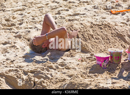 Bournemouth Dorset, Regno Unito. 2 Sep, 2017. Regno Unito: meteo bella calda giornata di sole a Bournemouth Beach. L'uomo mezzo sepolto nella sabbia. Credito: Carolyn Jenkins/Alamy Live News Foto Stock