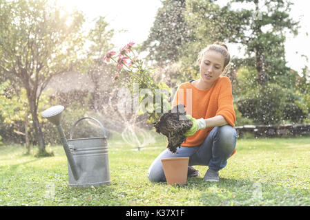 Yound donna nel suo giardino, nelle vicinanze di Vienna, Austria (modello-rilasciato) Foto Stock