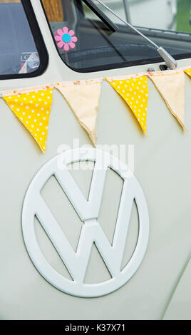 Anni Cinquanta VW split screen caravan estremità anteriore e giallo bunting a un vintage retrò festival. Regno Unito Foto Stock