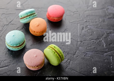 Classica francese amaretto multicolore biscotti nero su sfondo di calcestruzzo Foto Stock